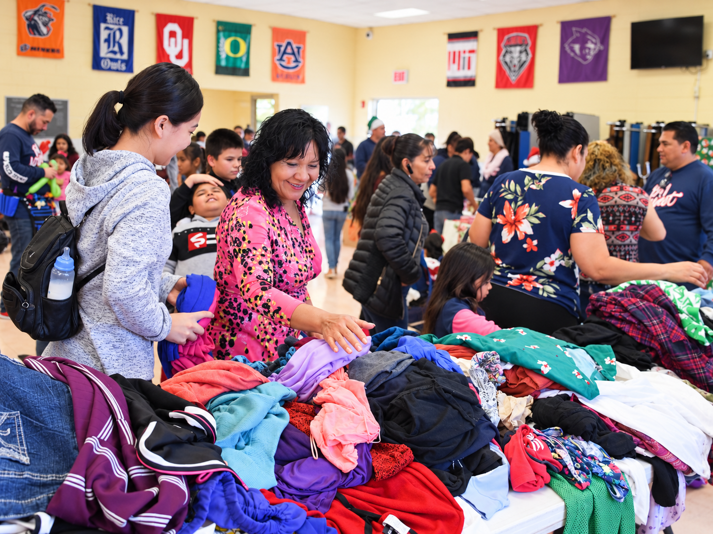 Volunteers and families sorting donated clothing and essentials at a community outreach event