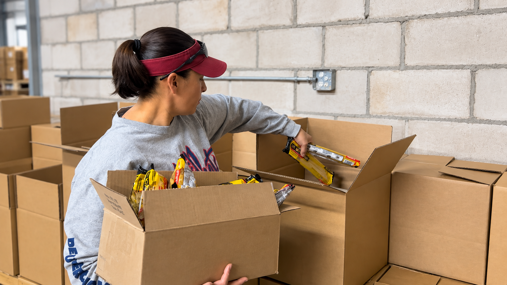 Volunteer packing boxes of food and essentials for community distribution
