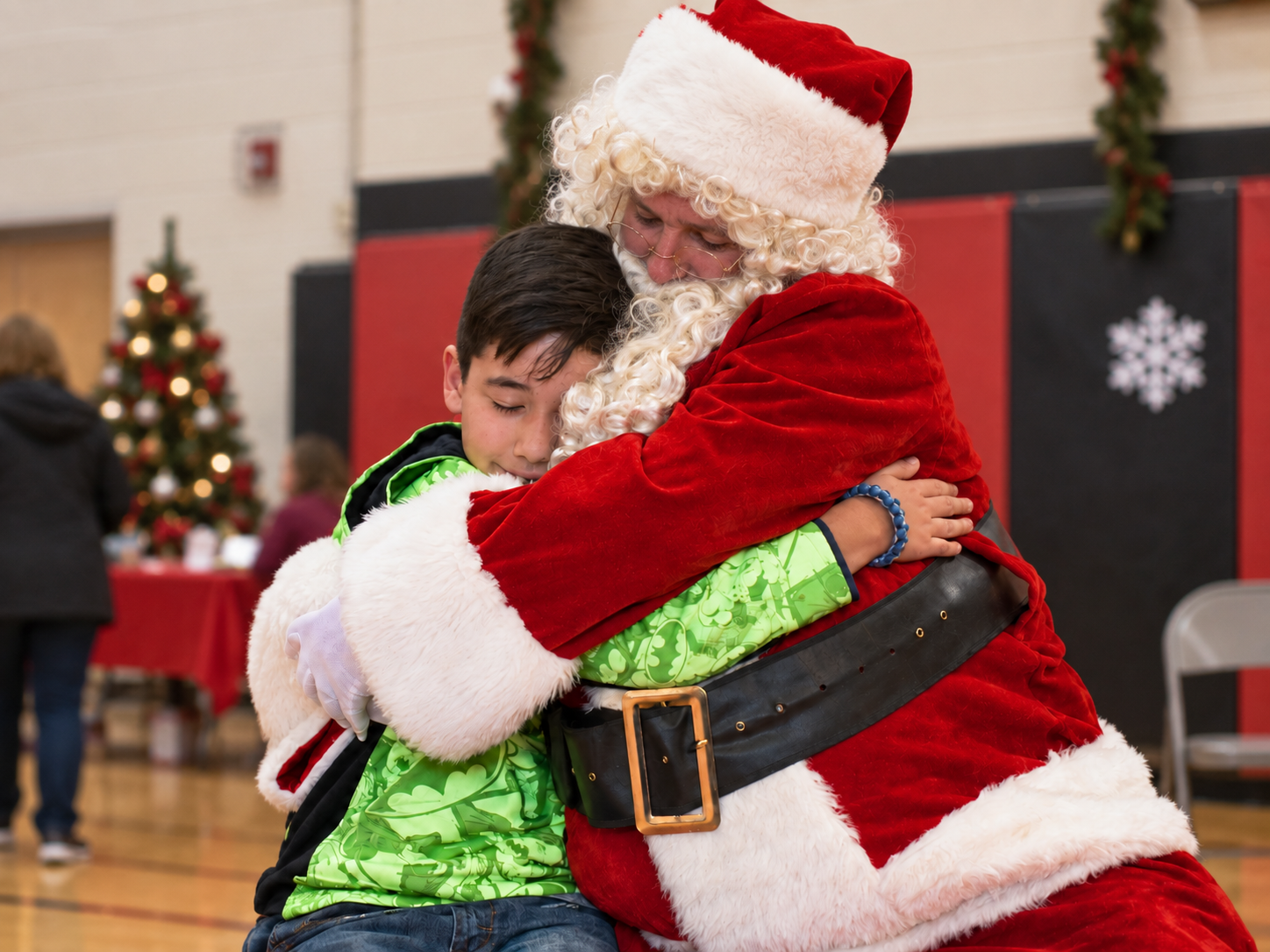 Santa Claus hugging a child at a Christmas community event