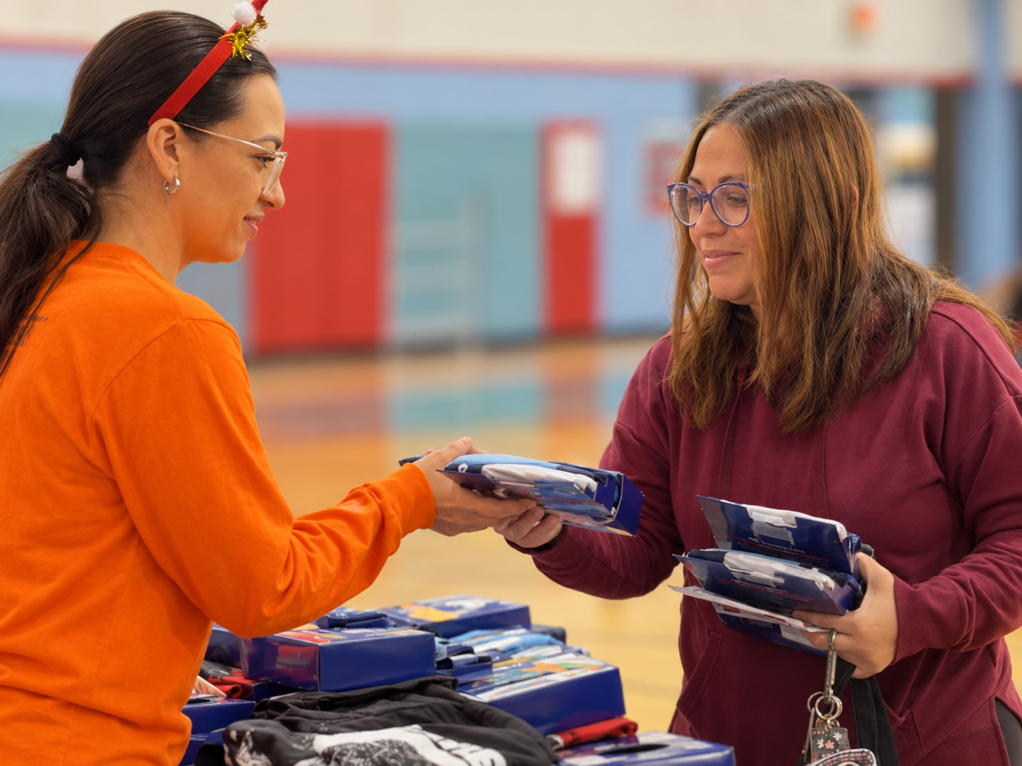 Two people handing out supplies at a community outreach table